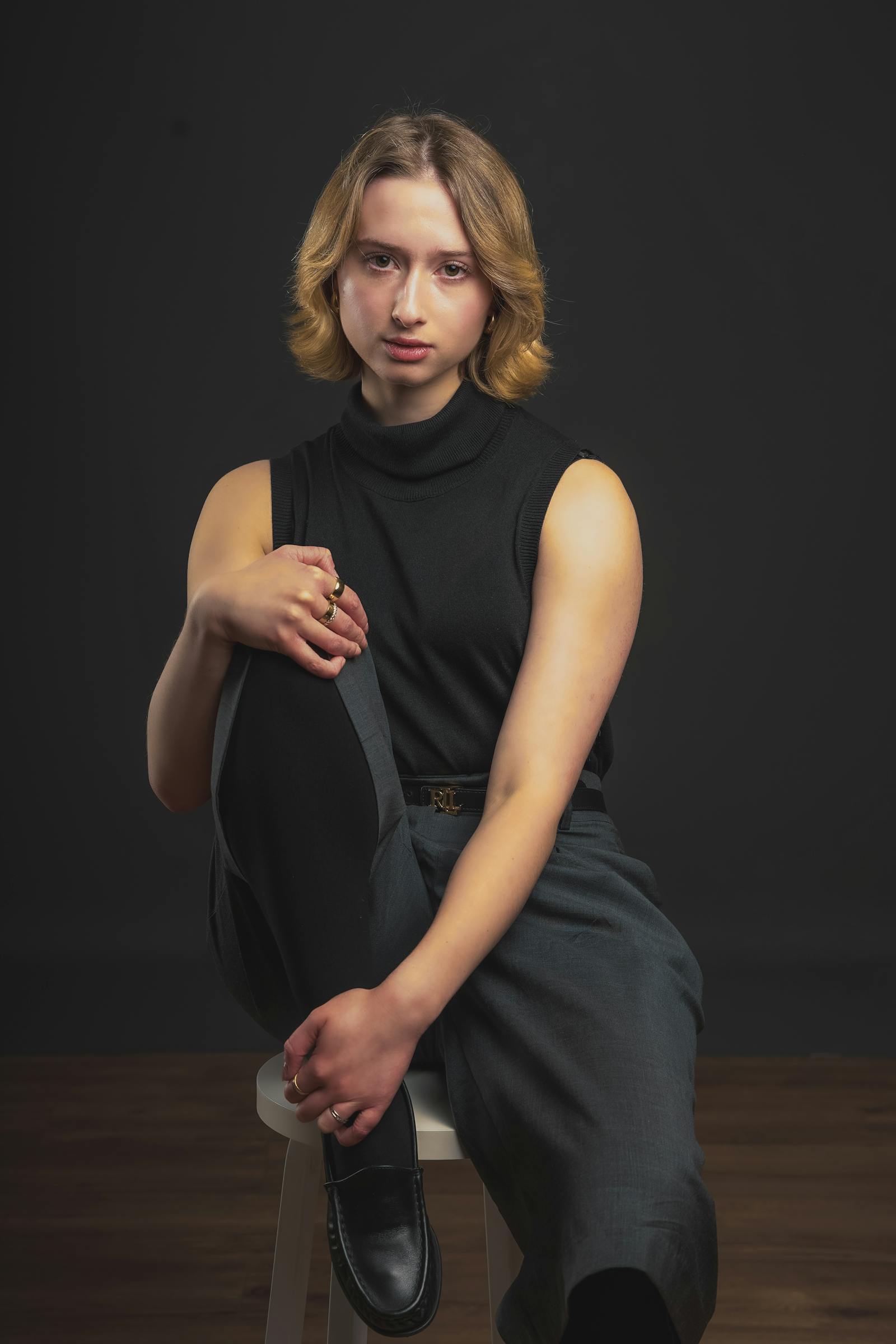 Studio portrait of Rosa Linder, in-house retoucher, with a serious expression in soft window light.